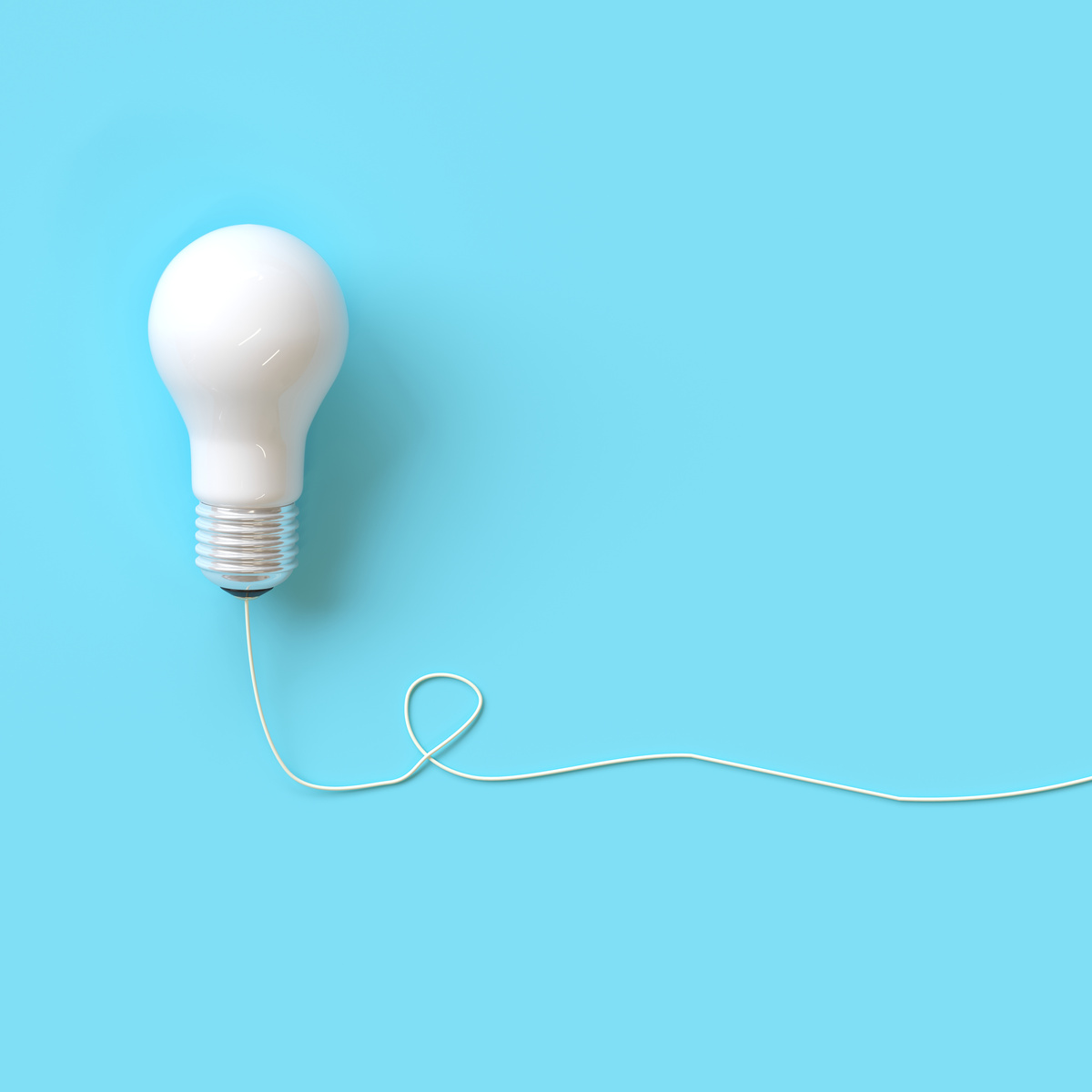 White light bulb with wire on blue background for copy space. minimal idea concept. top view